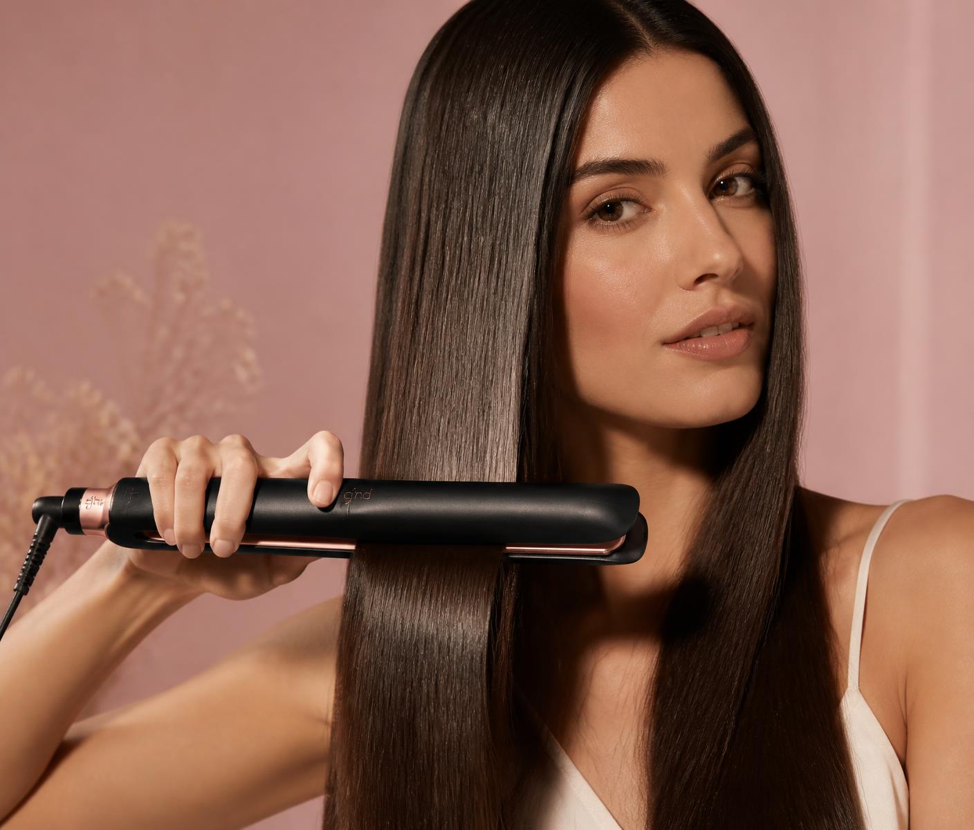 Mujer alisando su pelo con una plancha profesional